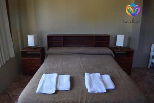1 dormitorio con 1 cama con 2 toallas en India en Chascomús