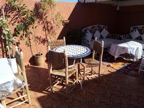 a patio with a table and chairs on a brick patio at Dar Dikrayat in Marrakech