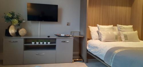 a bedroom with a bed and a flat screen tv at 51 Cocoa Suites,Rowntrees Wharf in York