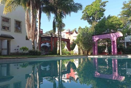 una piscina frente a una casa con palmeras en Hotel Hacienda Xico Inn, en Xico