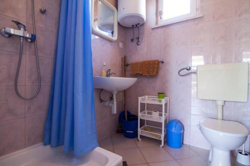 a bathroom with a shower and a sink and a toilet at Apartments Radić in Bol
