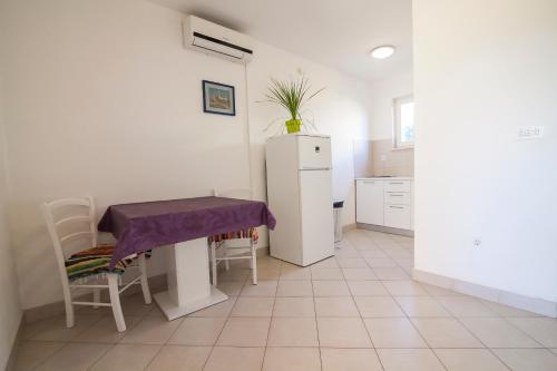a kitchen with a table and a refrigerator at Apartments Radić in Bol