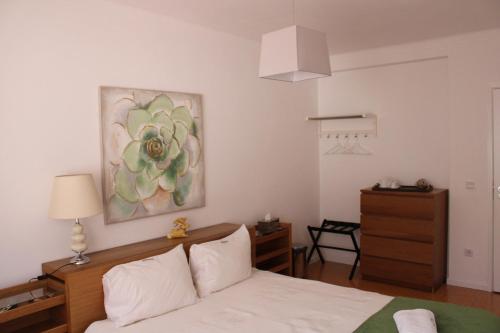 a bedroom with a bed and a painting on the wall at Casa Sandra - Apartamento Carlota in Lousã