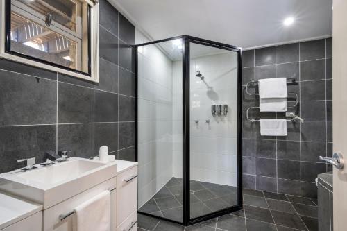 a bathroom with a shower and a sink at Pure Chalet Thredbo in Thredbo