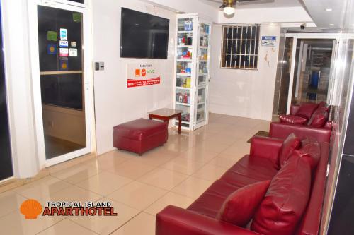 een wachtkamer met rode banken en een tv bij Awesome Studio-apartment For 2 Near Las Americas Airport and Colonial Zone in La Viva