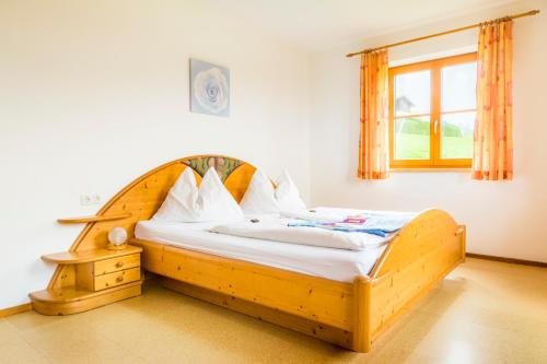 ein Holzbett in einem Zimmer mit Fenster in der Unterkunft Daarhof in Wagrain