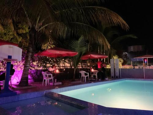 a swimming pool at night with tables and umbrellas at Woodpecker Resort Hotel in Bathurst