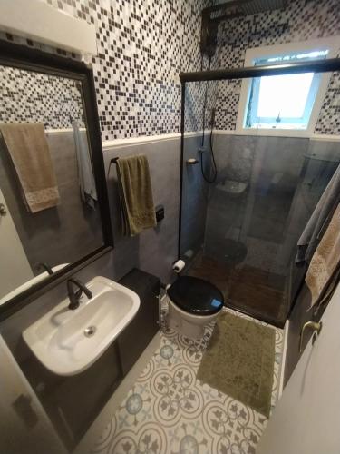 y baño con lavabo, aseo y ducha. en Foresthouse, en Florianópolis