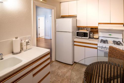 a kitchen with a white refrigerator and a sink at Harbor House Inn in Santa Barbara