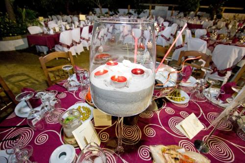 a table with a vase filled with water and food at Hostal El Cortijo in Algodonales