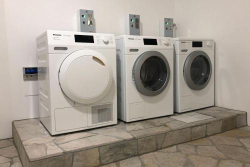 three washing machines and a dryer in a room at Apartments Griesser - Included BrixenCard and parking garage in house in Bressanone