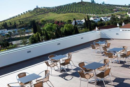 a patio with tables and chairs on a roof at Flag Hotel Villa Aljustrel in Aljustrel