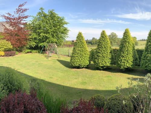 a garden with a playground in the middle of trees at Elegant Chalet in Malmedy with Private Garden in Malmedy