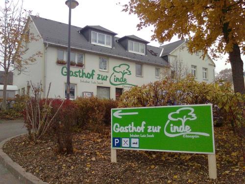 a sign in front of a house with a building at Gasthof zur Linde in Pausa