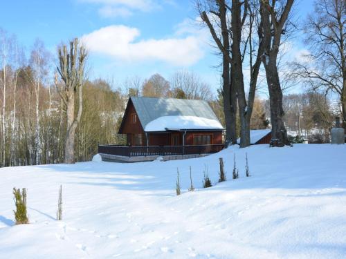 a red barn in a snow covered field with trees at home with well kept fenced in rice on the shore in Kyjov
