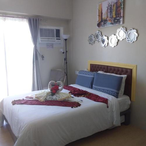 a bedroom with a bed with a teddy bear on it at AJ Sundiva Tower w balcony in Cebu City