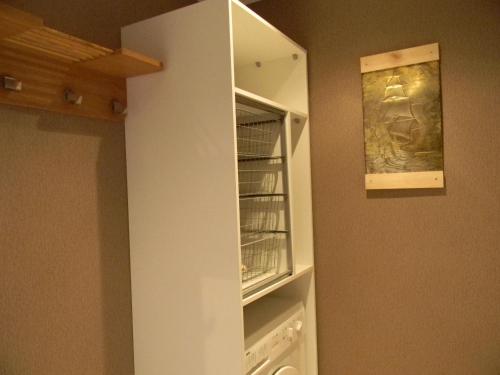 a white cabinet in a kitchen with a closet at Spordi Apartment in Narva