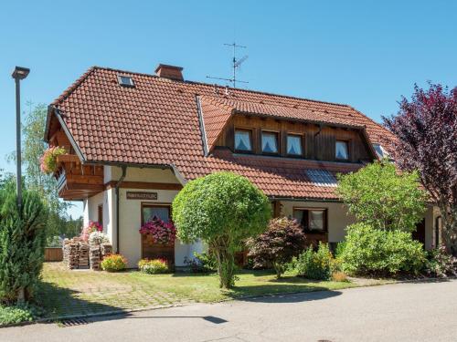 dom z czerwonym dachem wyłożonym kafelkami w obiekcie Holiday flat with balcony in Black Forest w mieście Furtwangen im Schwarzwald
