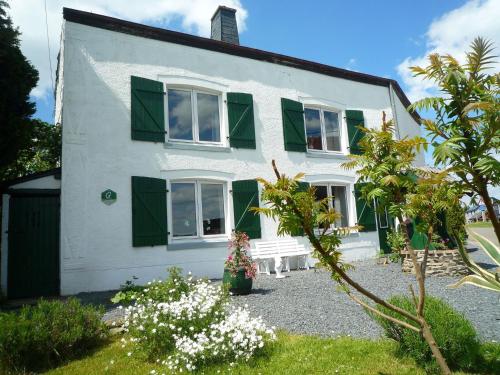 Una casa blanca con persianas verdes. en Beautiful and authentic cottage in the heart of the Ardennes, en Houffalize