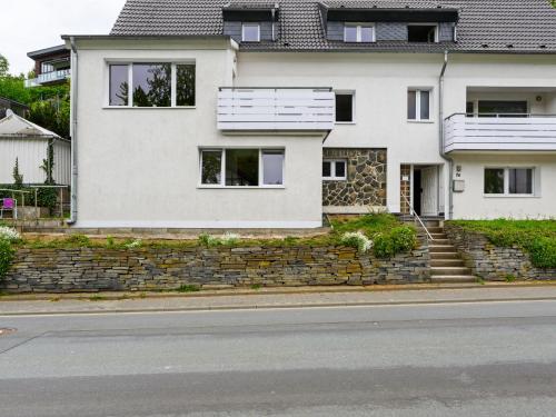 a white house on the side of a street at Well kept holiday home with terrace in Winterberg