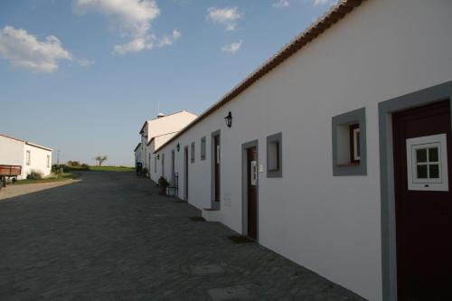 a row of white buildings on a street at Monte Da Morena Agro-Turismo in Serpa