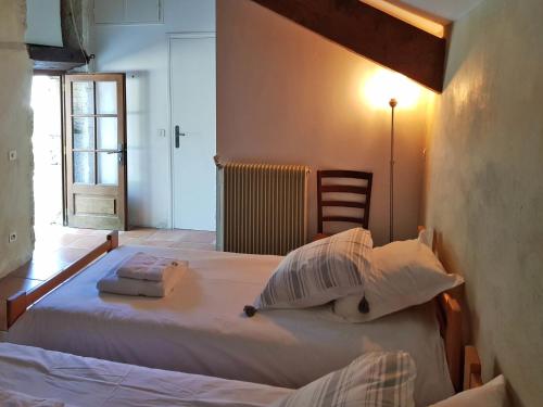 a bedroom with a large white bed and a chair at Farmhouse in Saint-Cernin with Pool & Views in Saint-Cernin