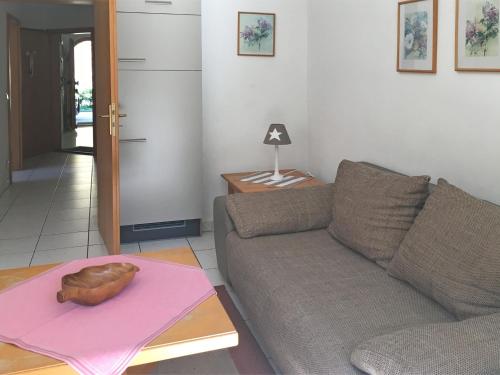 ein Wohnzimmer mit einem Sofa und einem Tisch in der Unterkunft Charming Apartment in Sch nau am K nigsee with Barbecue in Mitterbach