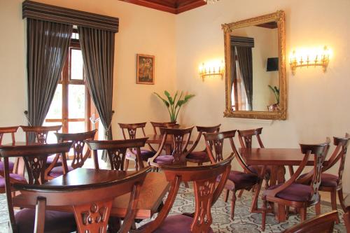 a room with tables and chairs and a mirror at La Casa del Marqués in Comitán de Domínguez