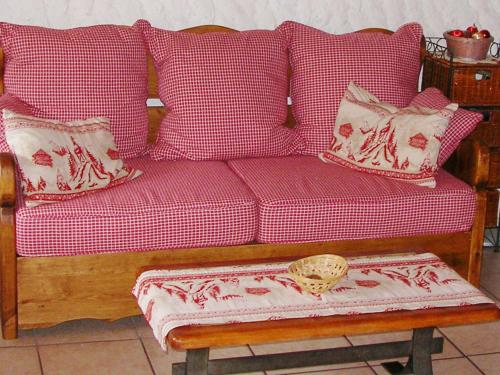 a couch with red and white pillows and a table at Charming Chalet in Champagny en Vanoise near Ski Area in Le Villard