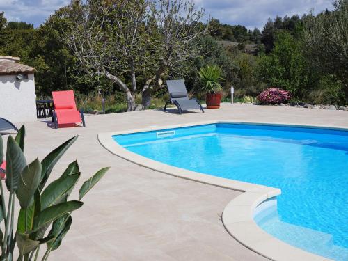 een zwembad in een tuin met twee stoelen bij Villa with pool in L zignan Corbi res in Lézignan-Corbières