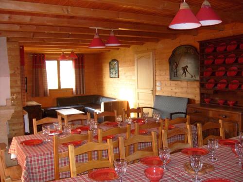 a dining room with a table and chairs with red plates at Rustic chalet with dishwasher, in the High Vosges in Le Ménil