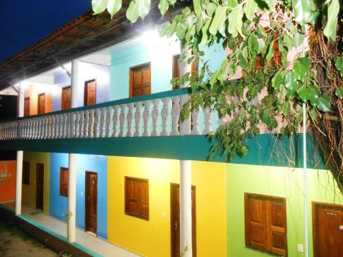 a colorful building with lots of doors on it at Pousada Salmo 23 in Algodoal