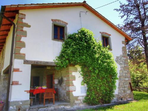 ein weißes Haus mit einem roten Tisch davor in der Unterkunft Modish Farmhouse in Ortignano with Swimming Pool in Castel Focognano