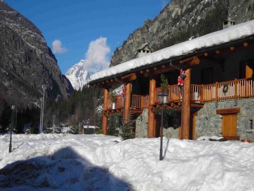 a building with a deck in the snow at Belvilla by OYO GrBe Bilo in Antey-Saint-André