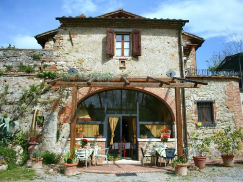 an entrance to a stone house with a patio at Belvilla by OYO Villa Rapolano in Rapolano Terme