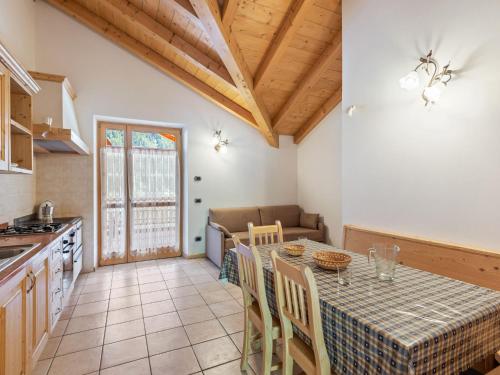eine Küche und ein Esszimmer mit einem Tisch und Stühlen in der Unterkunft Belvilla by OYO Il melo bianco in Caldes