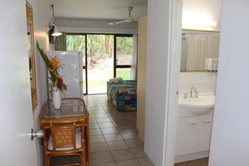 a kitchen with a sink and a refrigerator at Amaroo On Mandalay in Nelly Bay
