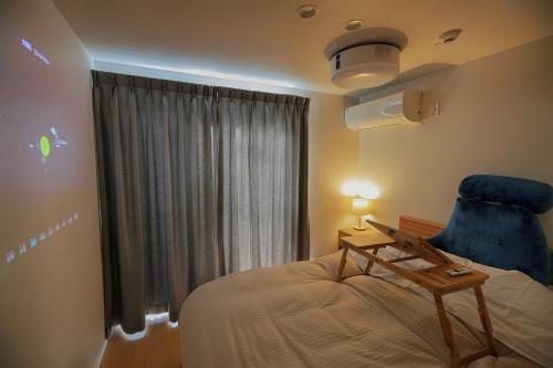 a bedroom with a bed and a blue chair at Fujiyasan in Fujikawaguchiko