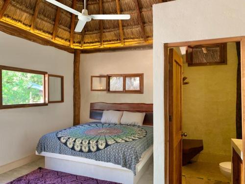 a bedroom with a bed and a ceiling at Tulum Nueve in Tulum