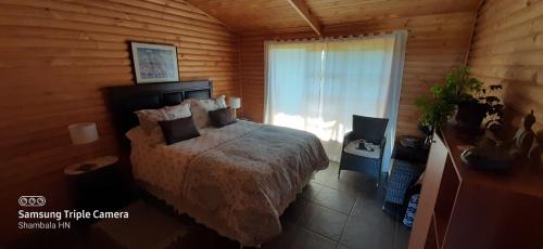 a bedroom with a bed in a wooden room at B&B Shambala HN in Pelarco