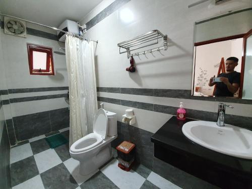 a bathroom with a toilet and a sink and a mirror at Tam Coc Friendly Homestay in Ninh Binh
