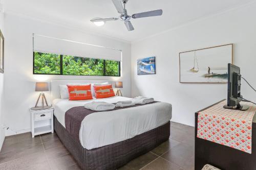 a bedroom with a bed and a flat screen tv at Noosa River Retreat Holiday Apartments in Noosaville