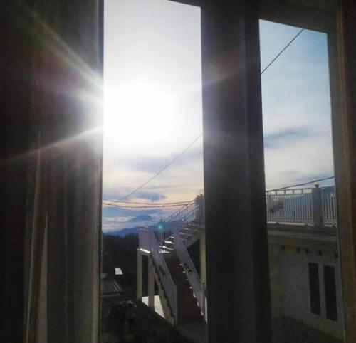 a view of the sun shining through a window at Bromo Otix Guest House in Bromo