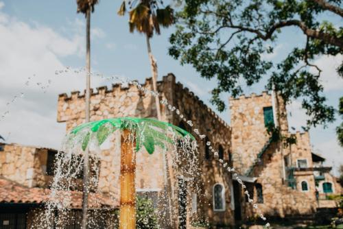 a fountain with a green umbrella in front of a building at Hotel El Castillo Chinauta in Chinauta
