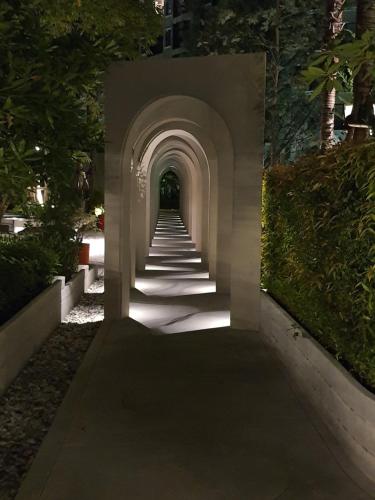 a pathway with an archway in a park at night at Lacasita484 In Huahin in Hua Hin