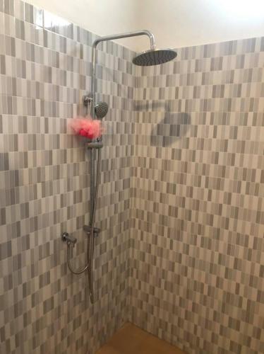 a shower in a bathroom with a tiled wall at Bemo Villas & Pool in Karangasem