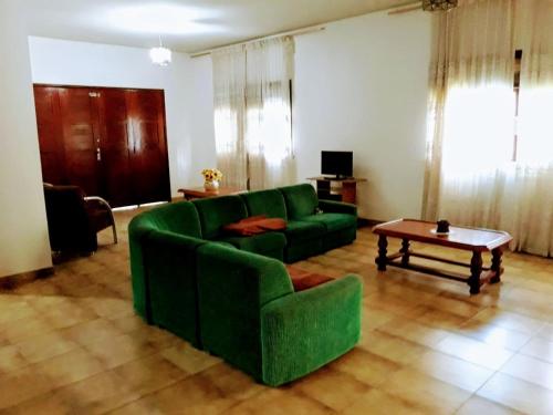 - un salon avec un canapé vert et une table dans l'établissement Casa para temporada em Cabo Frio, à Cabo Frio
