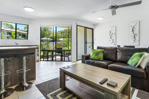 a living room with a couch and a table at Noosa River Retreat Holiday Apartments in Noosaville