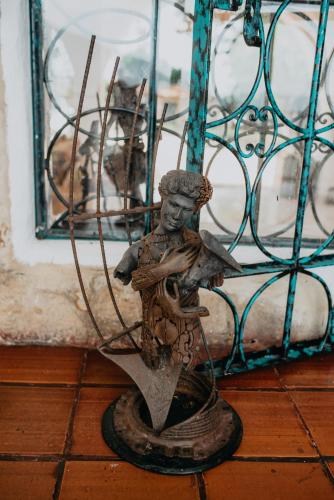 a statue of a man holding a bird in front of a window at Hotel El Castillo Chinauta in Chinauta