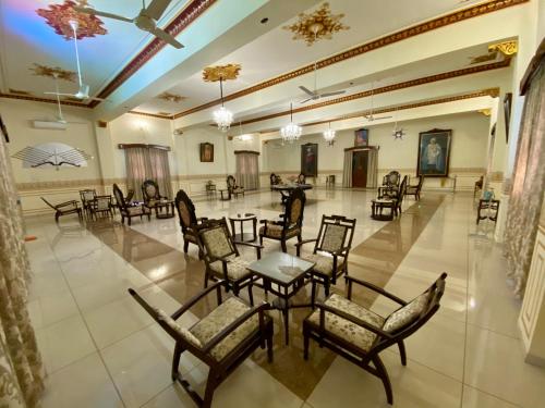 Großes Zimmer mit Stühlen und Tischen. in der Unterkunft Dowlat Villas Palace-The Heritage in Himatnagar